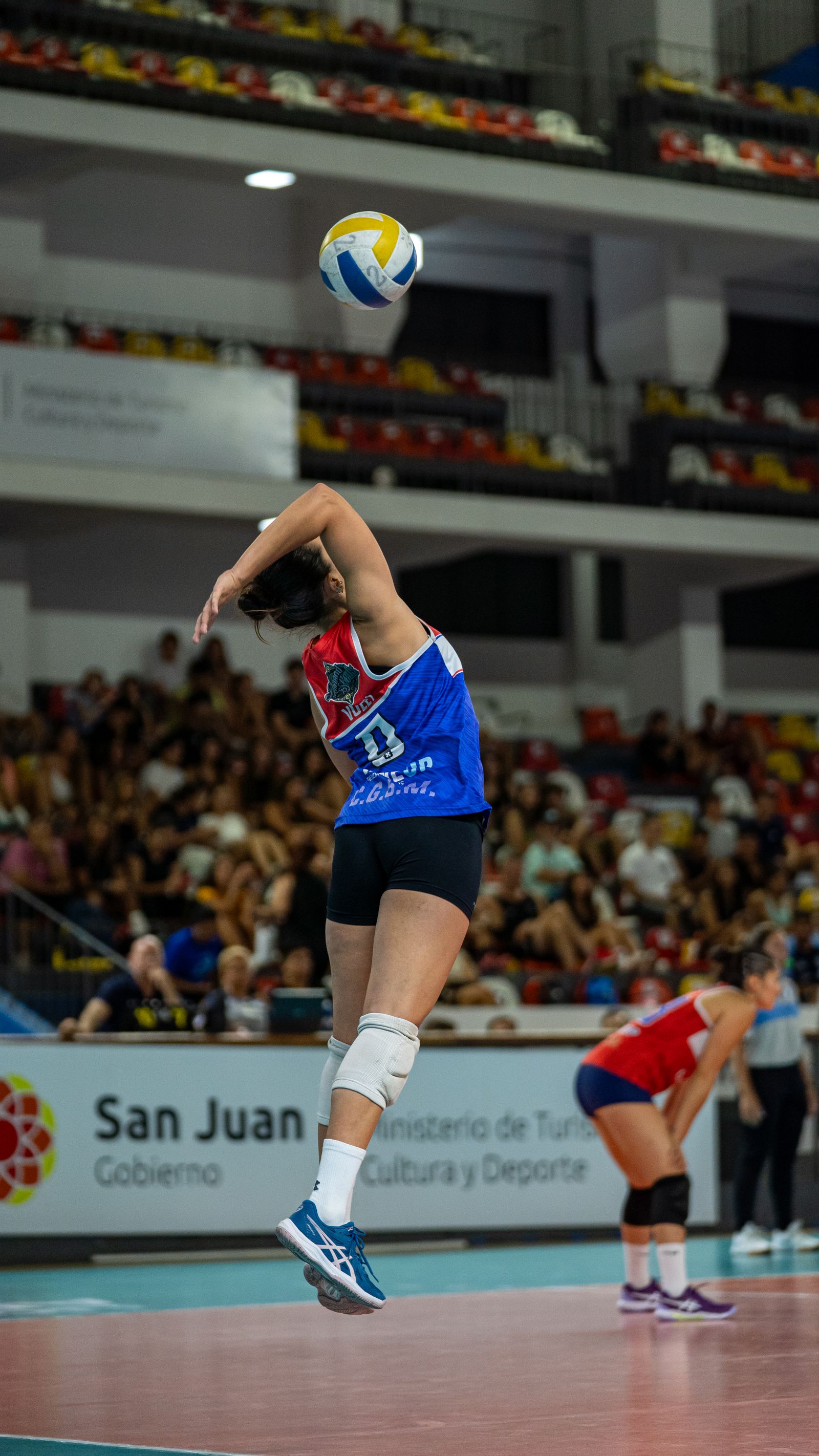 Women's volleyball player jumping indoors — the mark for the portal and the next move.